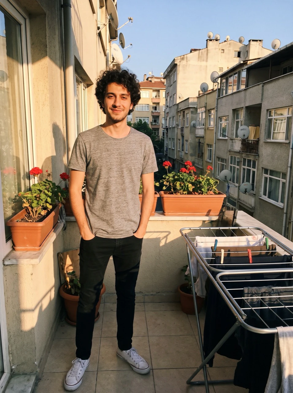 Can, balkonda gri tişörtle